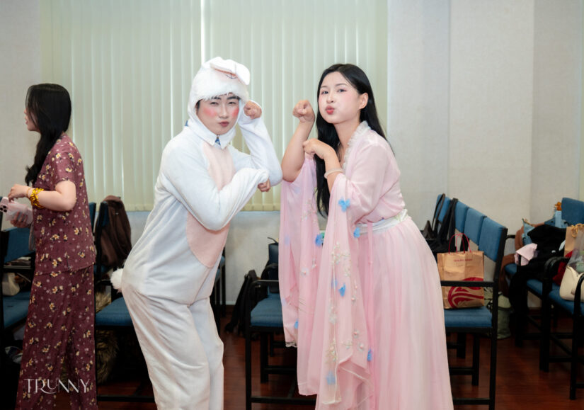 Hai thành viên hóa trang nhân vật cổ trang tạo dáng đối mặt nhau trong tiết mục