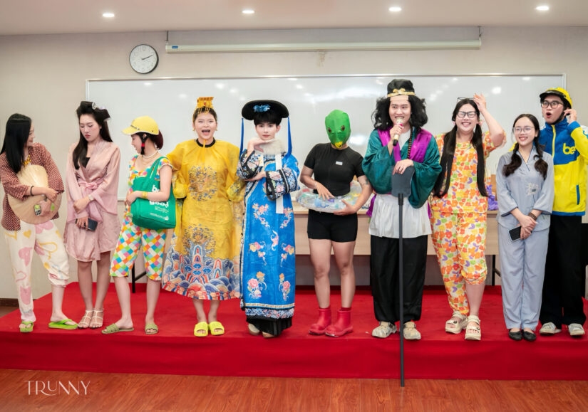 Các thành viên xếp hàng trên thảm đỏ trình diễn trang phục hóa trang trước khán phòng