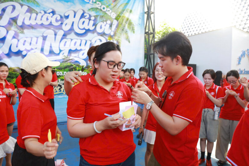 Hai thành viên trao phong bì quà tặng cho nhau trong trò chơi tại Host together 2026
