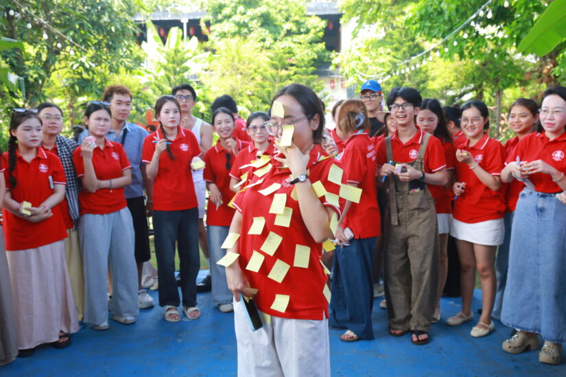 Một thành viên bị dán đầy giấy nhớ vàng làm người thua cuộc, cả nhóm đứng vây quanh cười