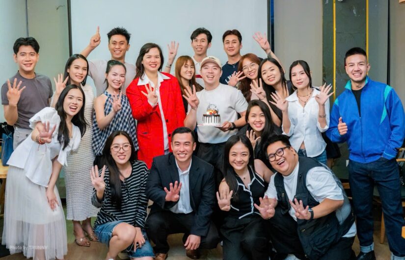 Tập thể học viên và giảng viên chụp ảnh chung, nhiều người giơ tay chào trong phòng học